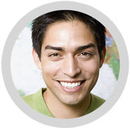 A young man smiling in front of a world map.