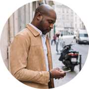 Un homme dans une veste bronzée regardant son téléphone.