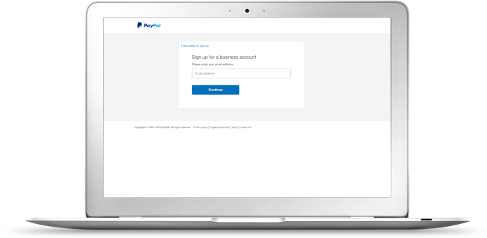 A laptop displaying the PayPal business sign up page.
