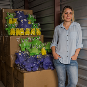 Woman standing in front of monster stuffed animals shipped using Freightos