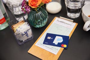 A PayPal card being used to pay a bill at a bistro. 