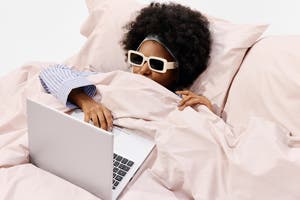 Woman in bed shopping on laptop