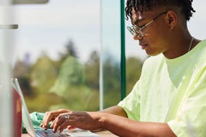 A sole trader business owner works from home on a laptop. 