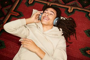 A man is smiling and listening to music