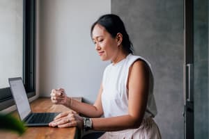 A person sitting in front of a computer screen with a stressed facial expression