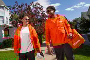 Two men smiling outside wearing Grubhub clothes