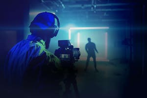 Independent music artist in a professional recording studio with camera equipment and blue lighting, representing the modern creator economy and digital content production