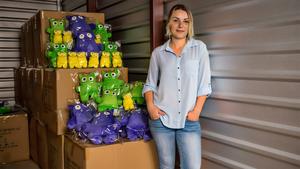 Woman standing in front of monster stuffed animals shipped using Freightos
