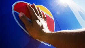 Person’s hand touching Southwest Airlines logo.