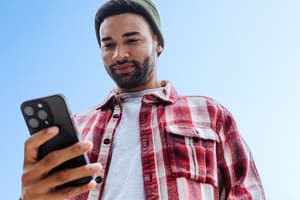 A man in a red flannel learning the differences between mobile banking vs. online banking on his mobile phone.