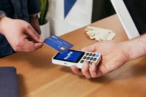 Eine Person, die mit einer Kreditkarte einen Einkauf tätigt.