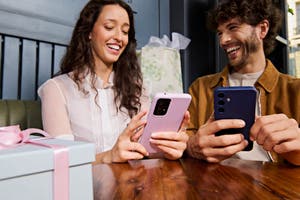 A couple shops online on their phones.