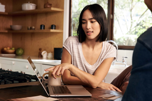 Une personne utilise son ordinateur portable pour effectuer un transfert d'argent sécurisé.