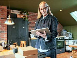 Une personne traite ses commandes depuis son domicile, montrant comment PayPal peut par exemple vous venir en aide lorsque vous êtes pris dans le tumulte de votre activité professionnelle