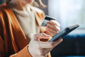 Hands of woman holding a credit card and using smart phone for online shopping