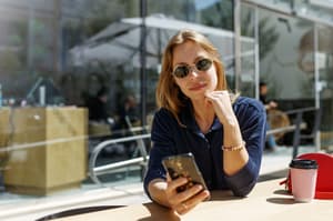 A women holding her smart phone using Instagram to promote her business.