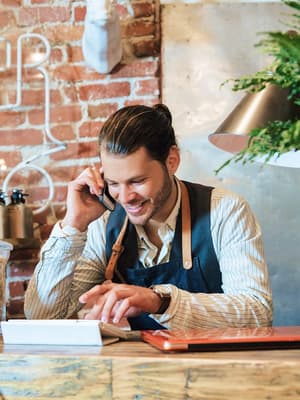Un homme d'affaires parle sur son téléphone portable et vérifie les informations sur sa tablette