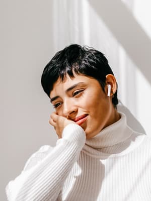 Femme souriante avec des écouteurs, un lien vers la page Paiement en 4X, montrant un exemple d'utilisation de PayPal