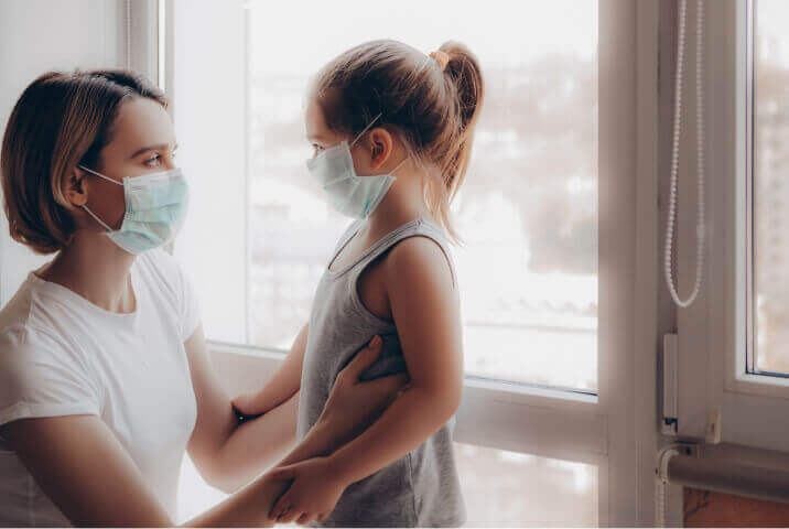 A mother and her child, who are similar to the people that GiveDirectly aids, wear face masks due to the COVID-19 pandemic