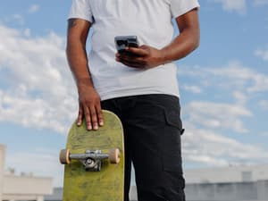 Person holding a phone and skateboard