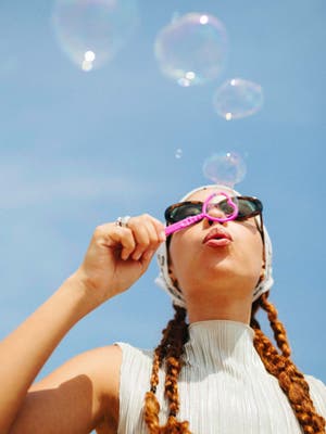 Woman blowing bubbles outside