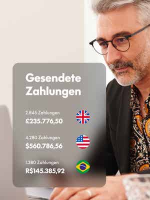 Ein Mann arbeitet am Laptop und sieht auf dem Overlay Geld aus der EU, USA und Brasilien.