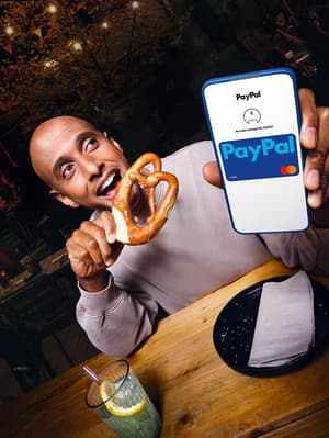Kunde bezahlt kontaktlos mit Smartphone am Kartenlesegerät.