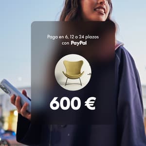 Persona sonriente usando su teléfono al aire libre con la superposición “Paga en 6, 12 o 24 plazos”