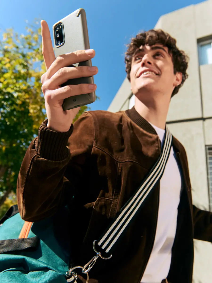 Hombre sonriente levantando un teléfono