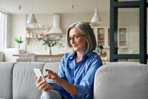 Senior woman using her phone at home