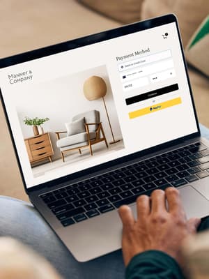 Person working on laptop computer with UI of PayPal checkout