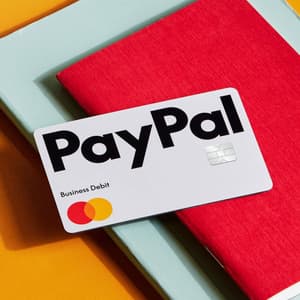 Red notebook with a PayPal Business Debit Card on top of it