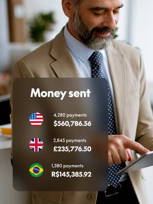 Person working on tablet with overlay of Money sent in different currencies
