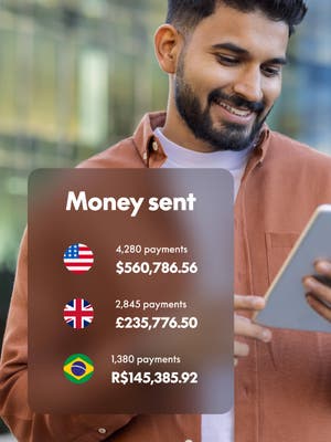 Person working on tablet with overlay of Money sent in different currencies