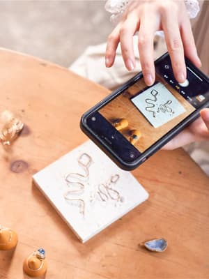 Person taking of their work with a smartphone