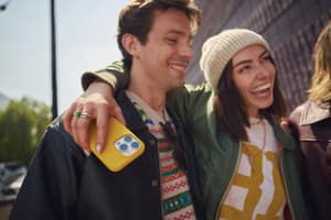 A woman holding a phone and smiling with her arm around a man