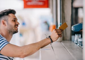 A man pays with his credit card at a counter.