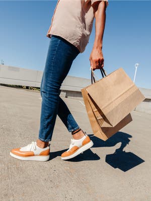 Person holding multiple shopping bags walking in a parking garage