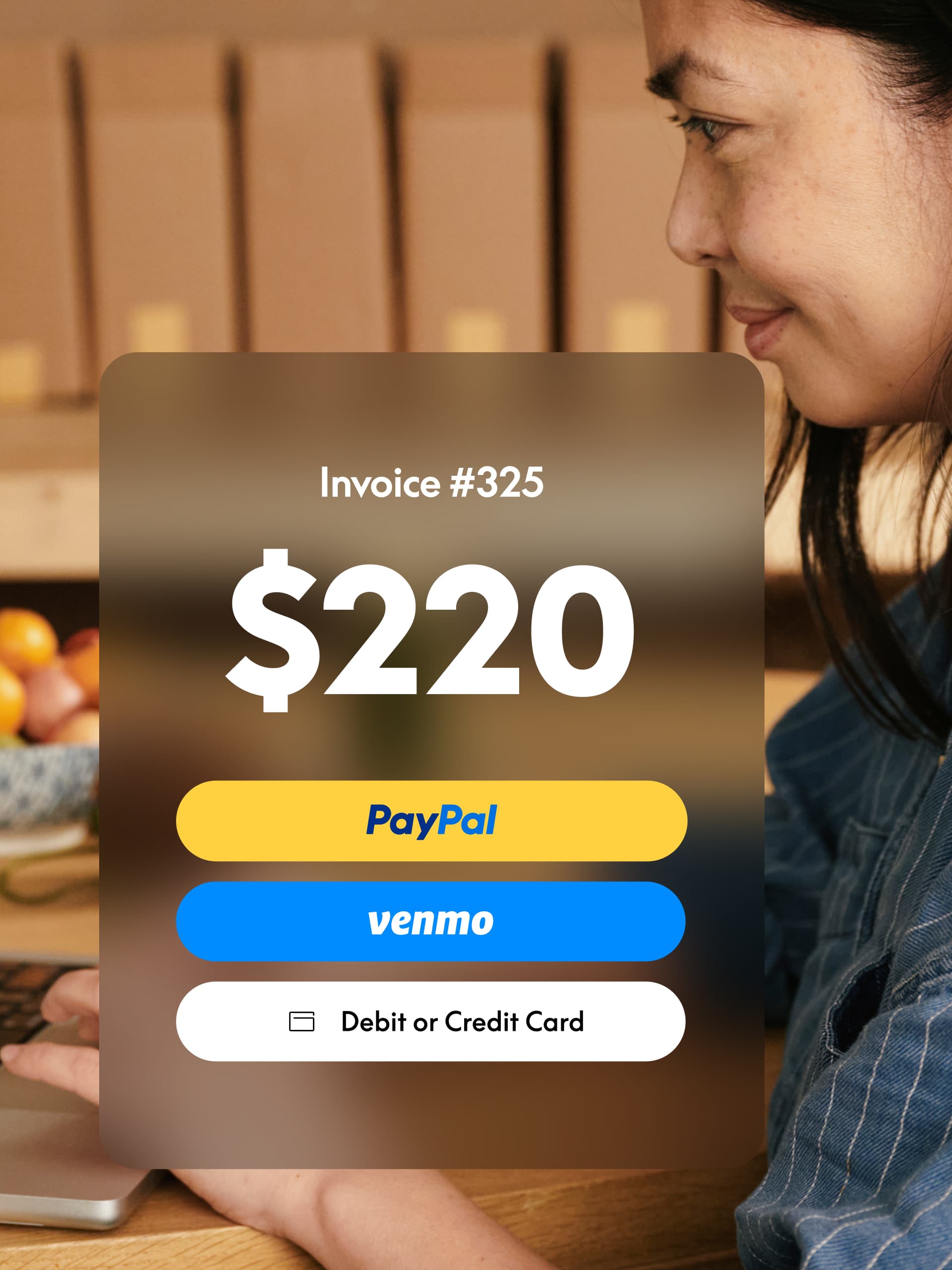 Woman working on laptop with invoice overlay showing $220 due and options to pay with PayPal, Venmo, or credit or debit card