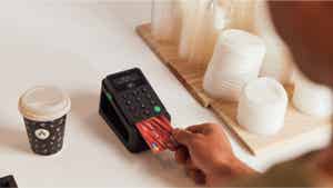 A person paying for a drink at a cafe with a credit card.