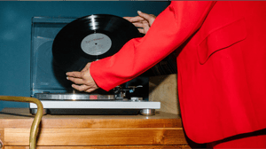 A person placing a  vinyl on their record player.