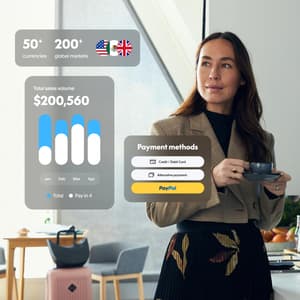 A professional woman in a sunlit office space holds a teacup and reflects on all the ways PayPal Open is helping her business.