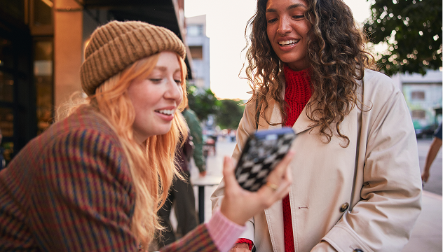 Two women holding phone