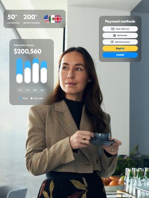 A professional woman in a sunlit office space holds a teacup and reflects on all the ways PayPal Open is helping her business.