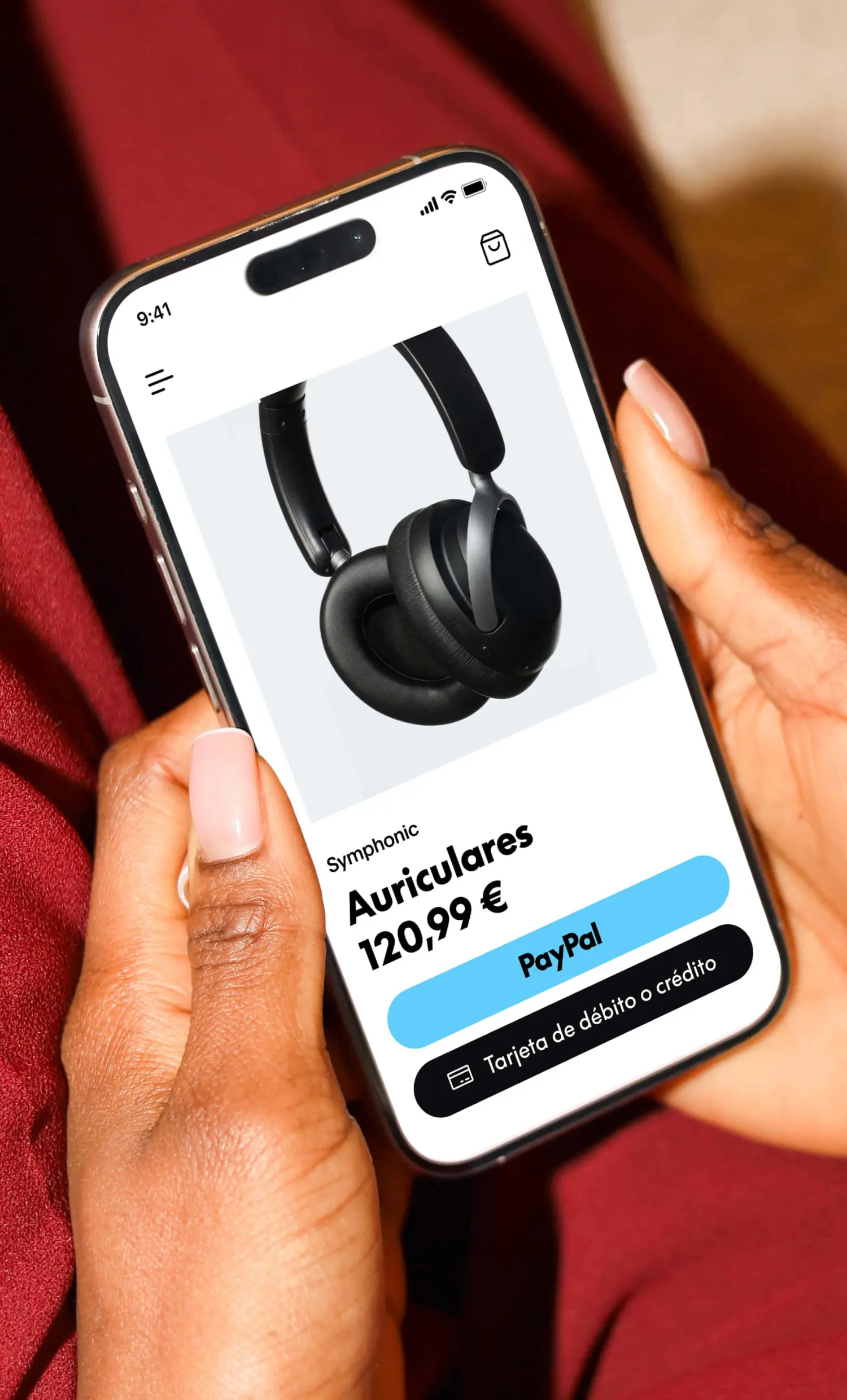 Una persona sosteniendo un teléfono junto a unos auriculares