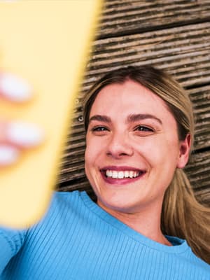 Woman laying outside looking at her phone