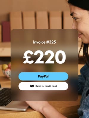 Woman working on laptop with invoice overlay showing £220 due and options to pay with PayPal, or credit or debit card