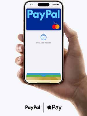 Hand holding an iPhone showing Apple Wallet with a PayPal debit card and reads “Hold Near Reader”.
