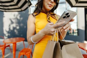 A woman checking out shopping purchases on her phone.